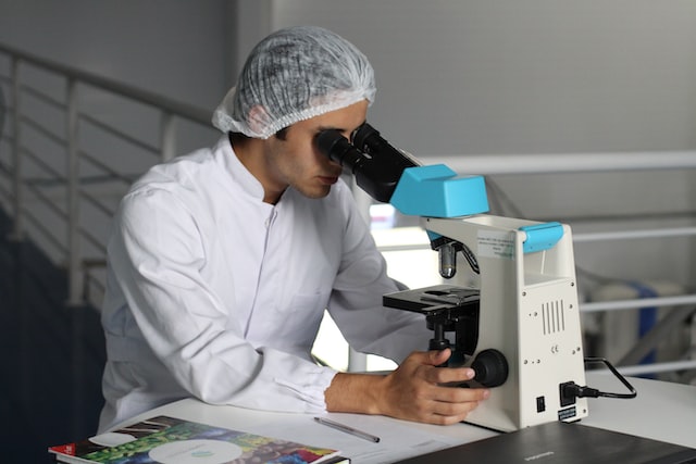scientists looking through a microscope 